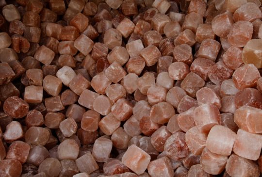 A pile of rough-hewn pink Himalayan salt cubes.